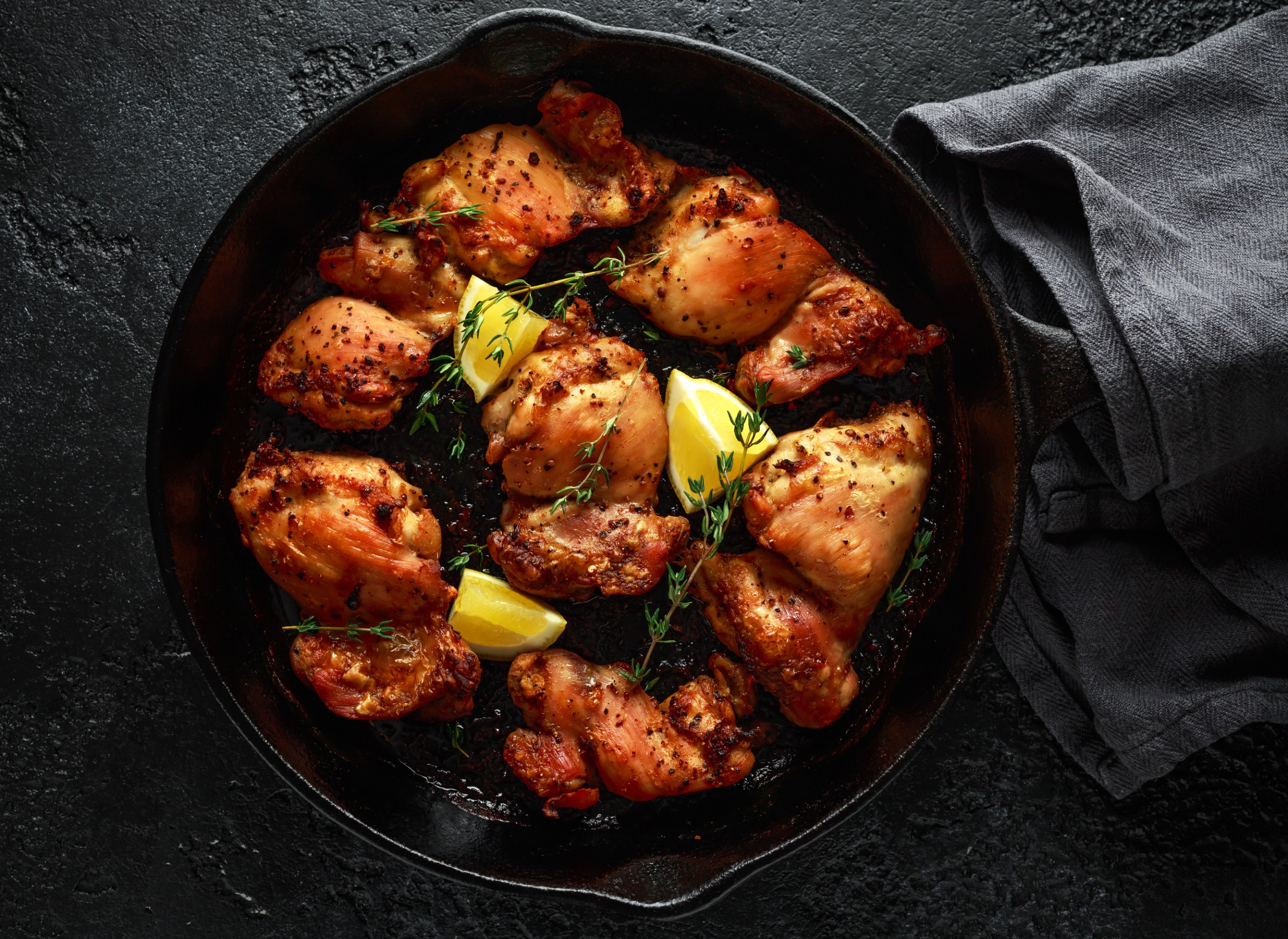 Chicken thighs in a skillet.