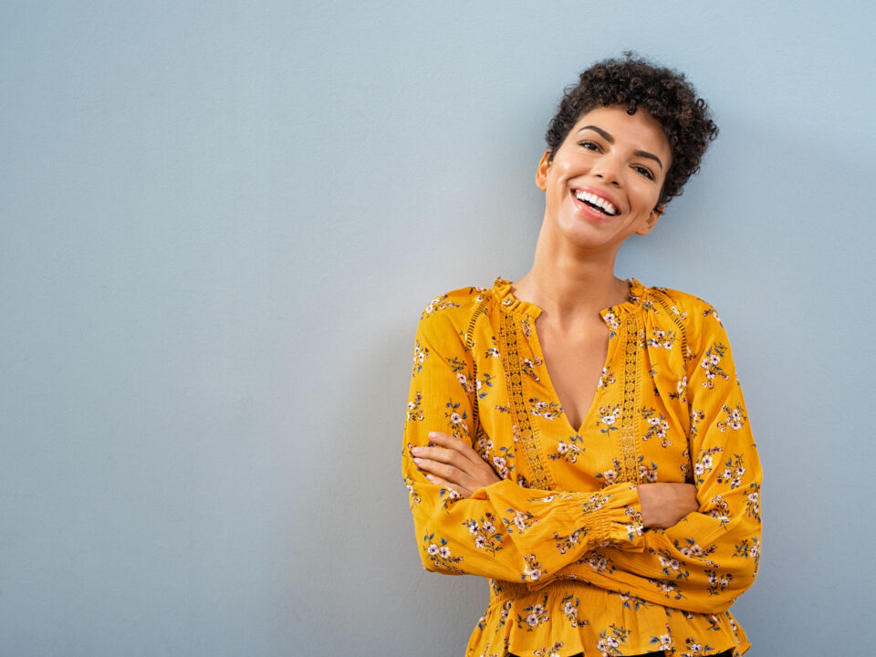 a smiling woman in a yellow top