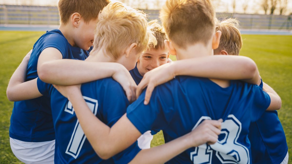 Soccer team huddling up before game.