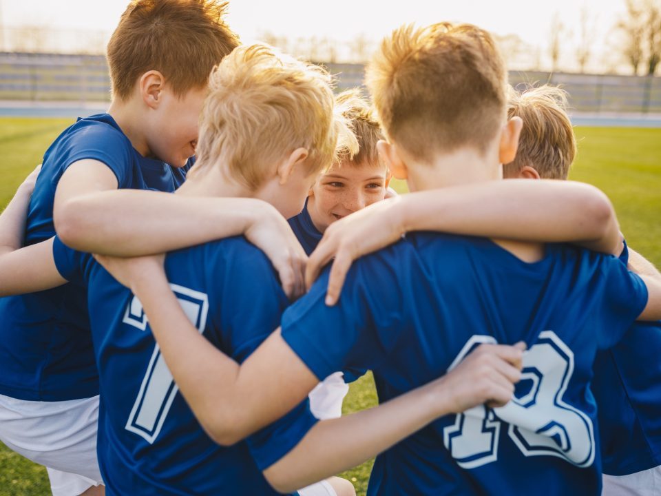 Soccer team huddling up before game.