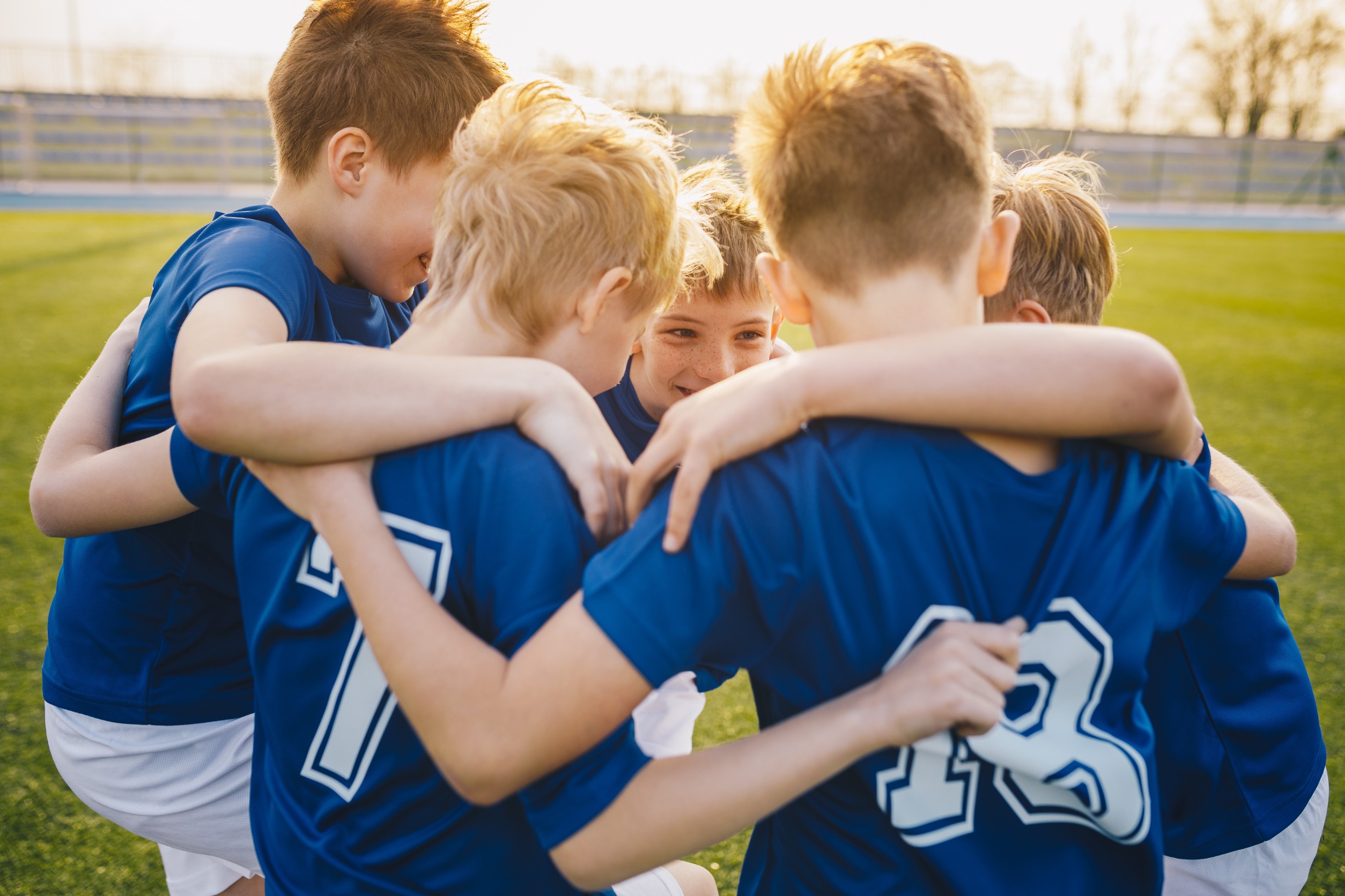 Soccer team huddling up before game.