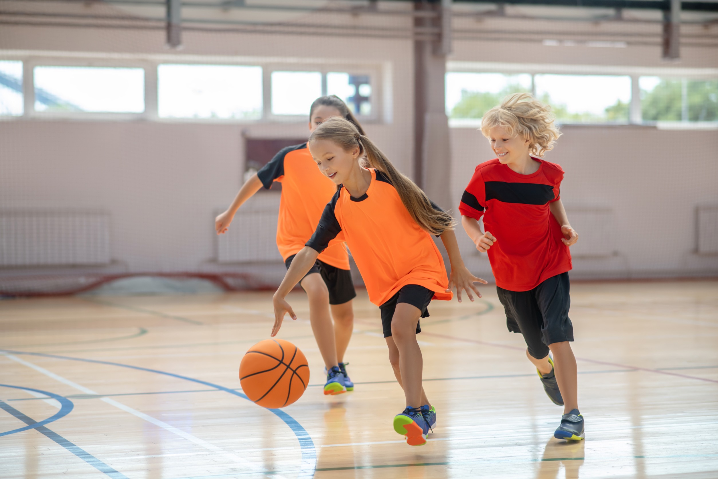 Children playing basketball, one of the youth sports offered at the Y!