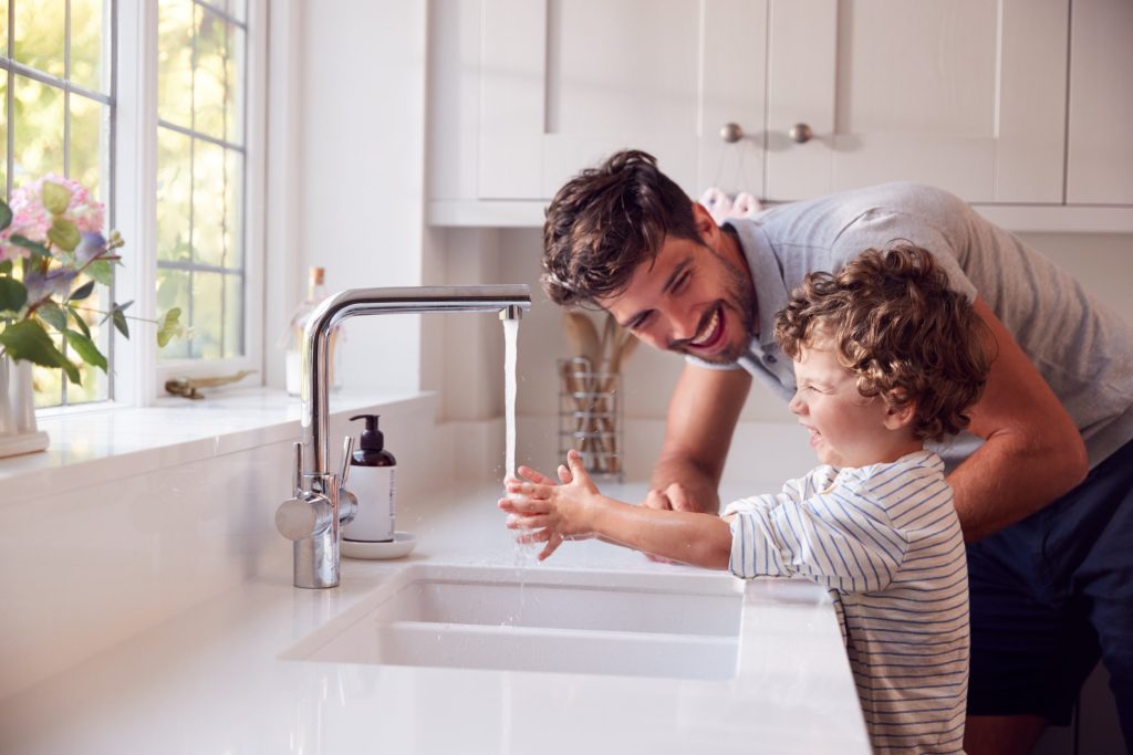 Father teaching his son how to wash his hands