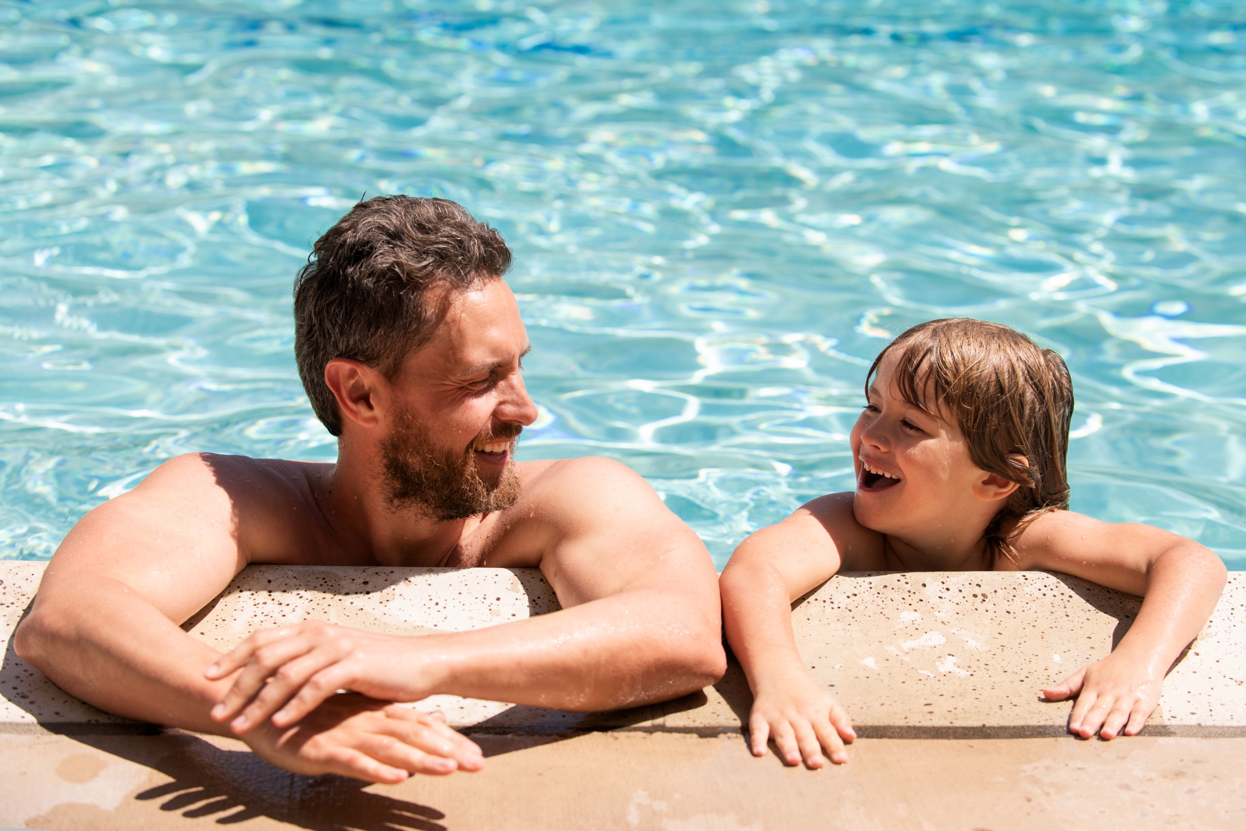 Father and son having fun in pool