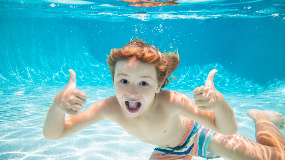 Young boy swimming underwater