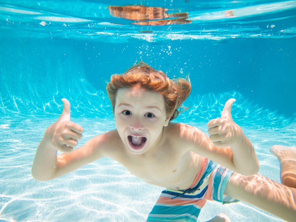 Young boy swimming underwater