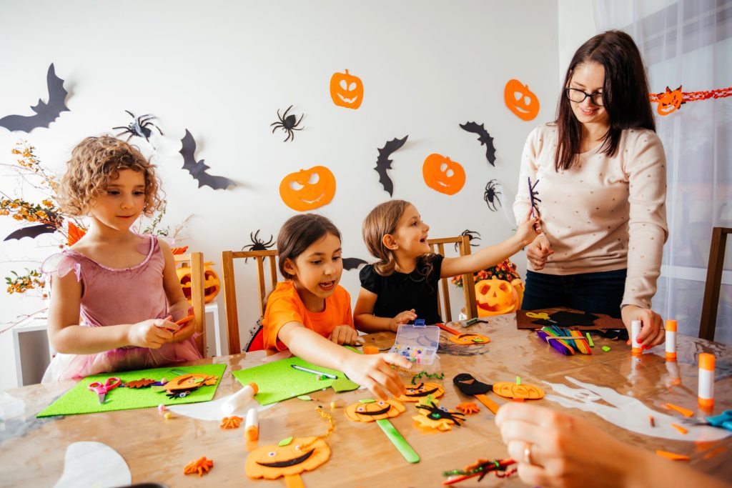 Family celebrating Halloween by making festive crafts.