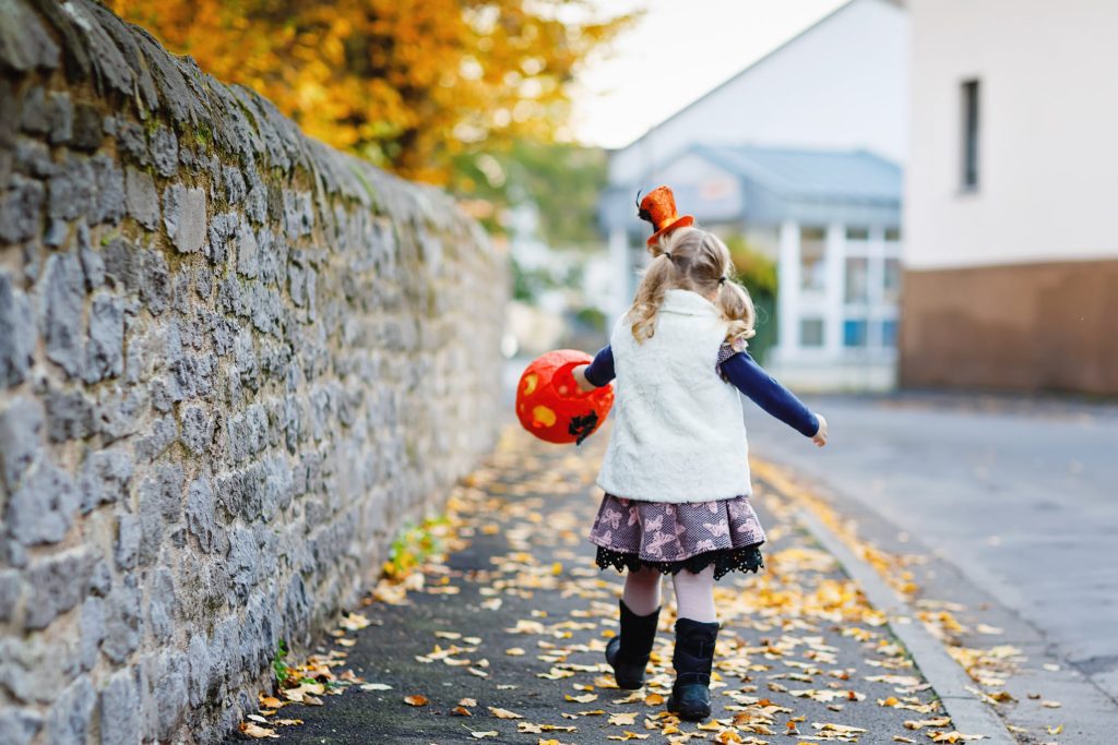 Little girl walking while trick-or-treating.