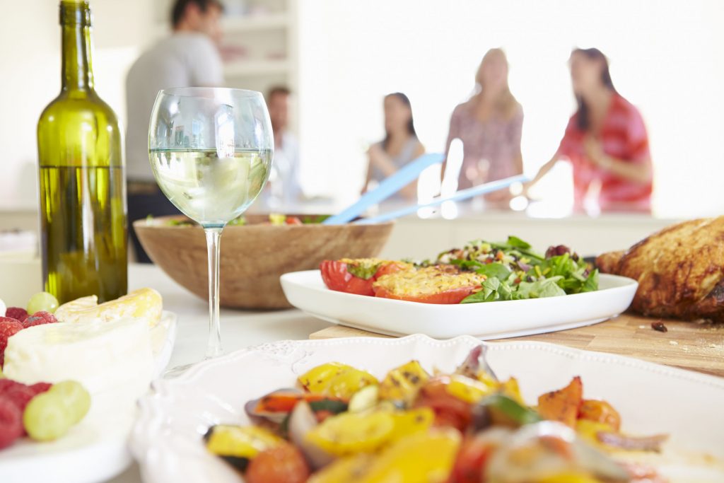 friends enjoying wine, turkey, peppers, and more during Thanksgiving