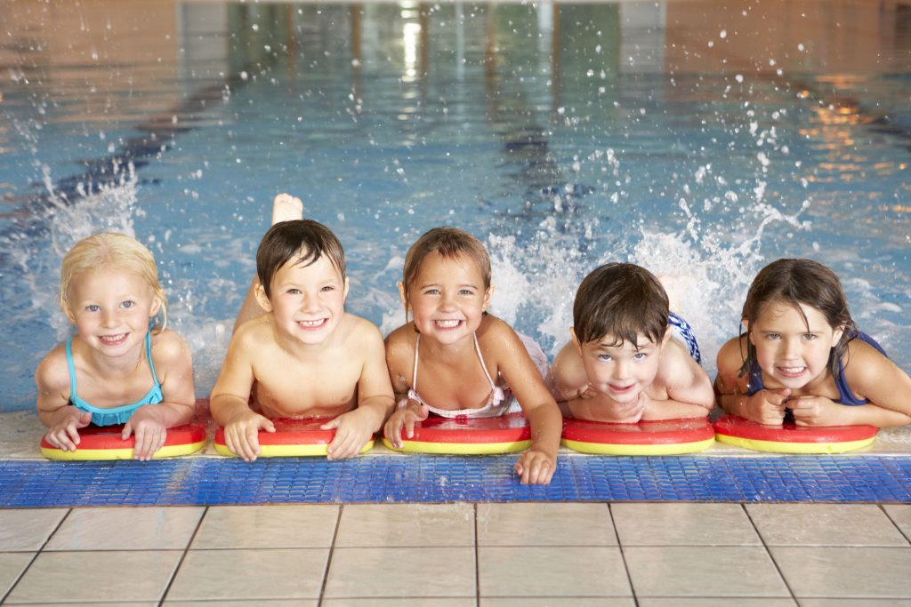 five happy children in a swimming pool