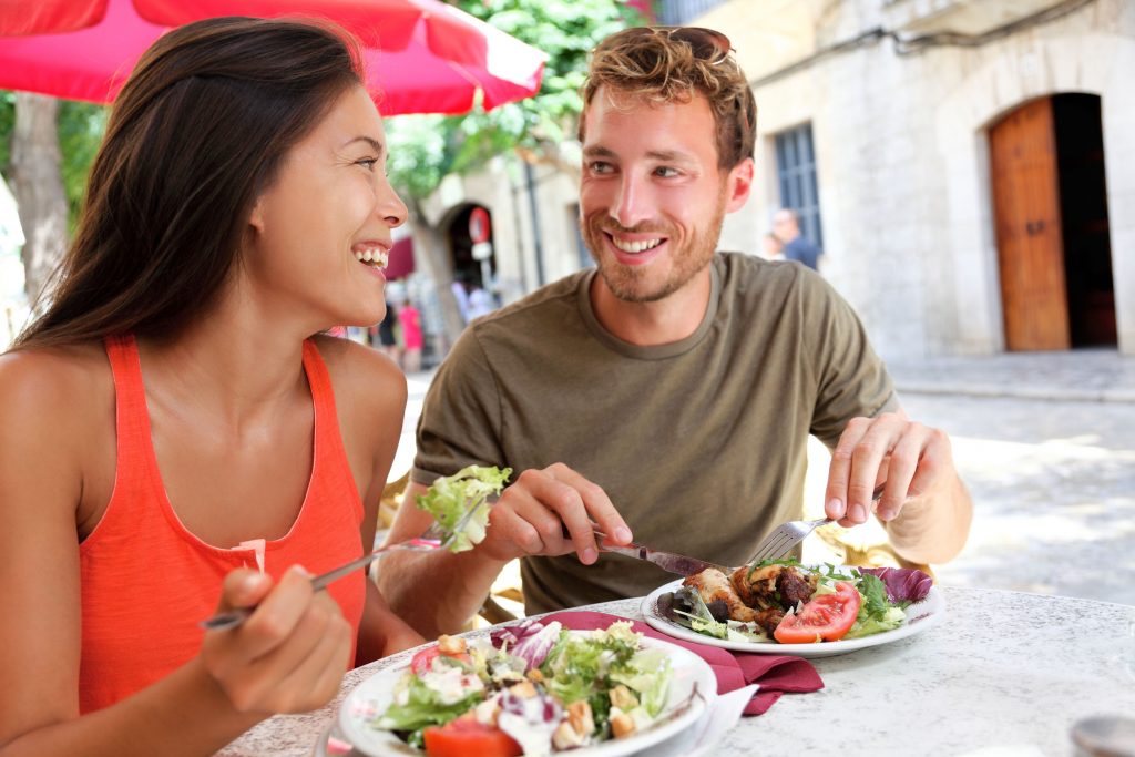 male and female college friends eating lunch together outdoors