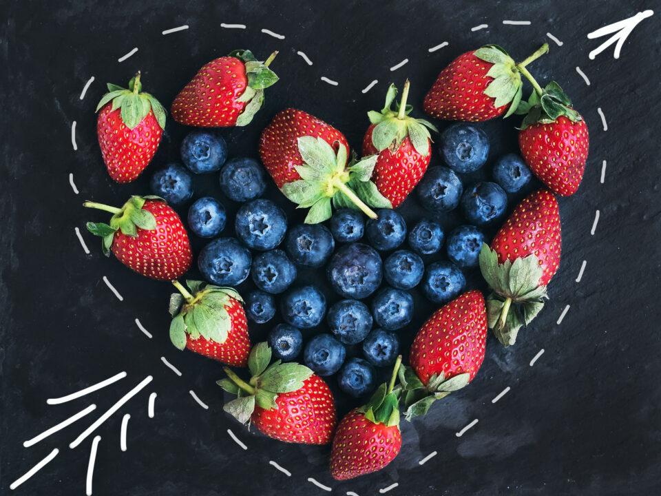 strawberries surrounding blueberries in a heart-shaped outline, symbolizing a healthy Valentine’s Day