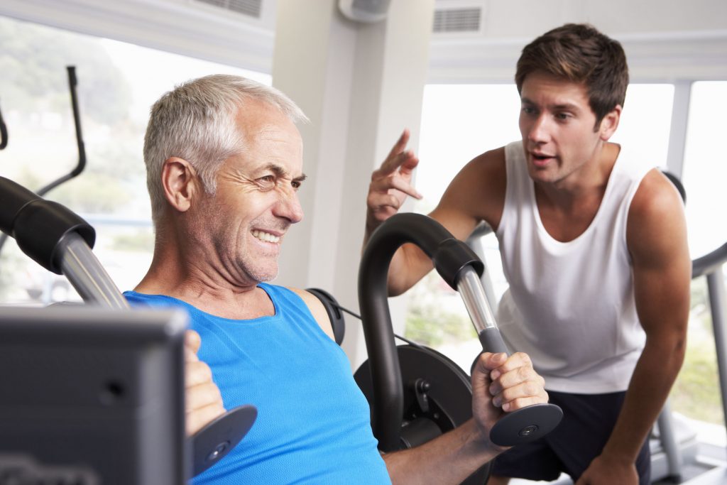 young personal trainer encouraging a motivated middle-aged man