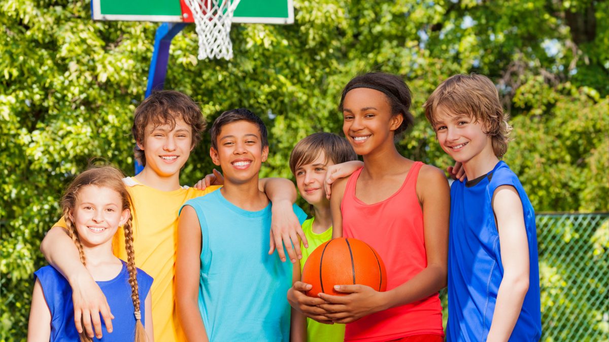 boys and girls playing basketball together outside