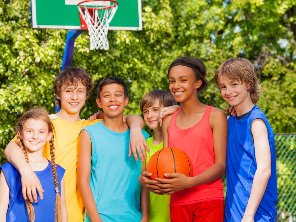 boys and girls playing basketball together outside