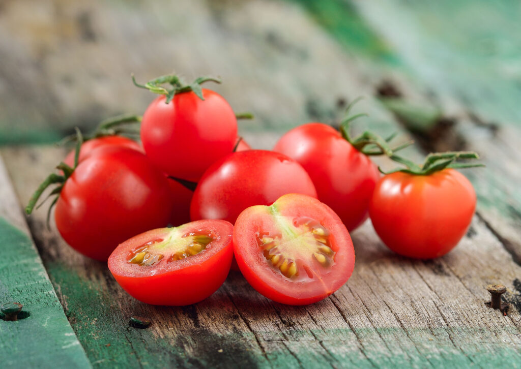 ripe tomatoes on a wooden picnic table outside