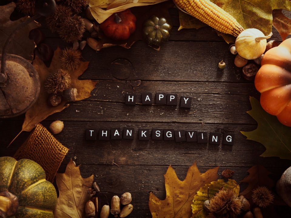 fall fruits and vegetables on a wooden table with “Happy Thanksgiving” letters