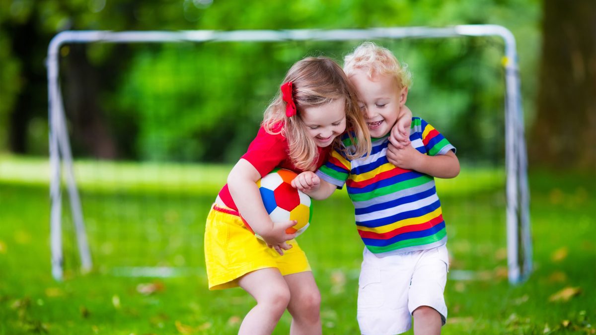 brother and sister hugging during a game of soccer