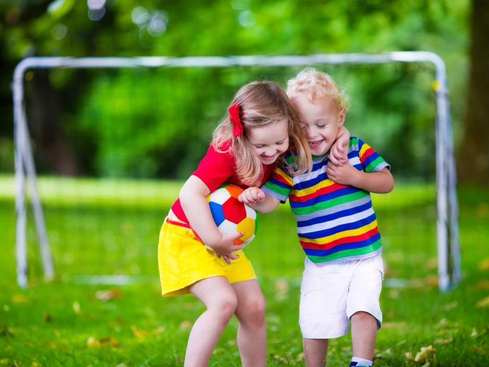 brother and sister hugging during a game of soccer