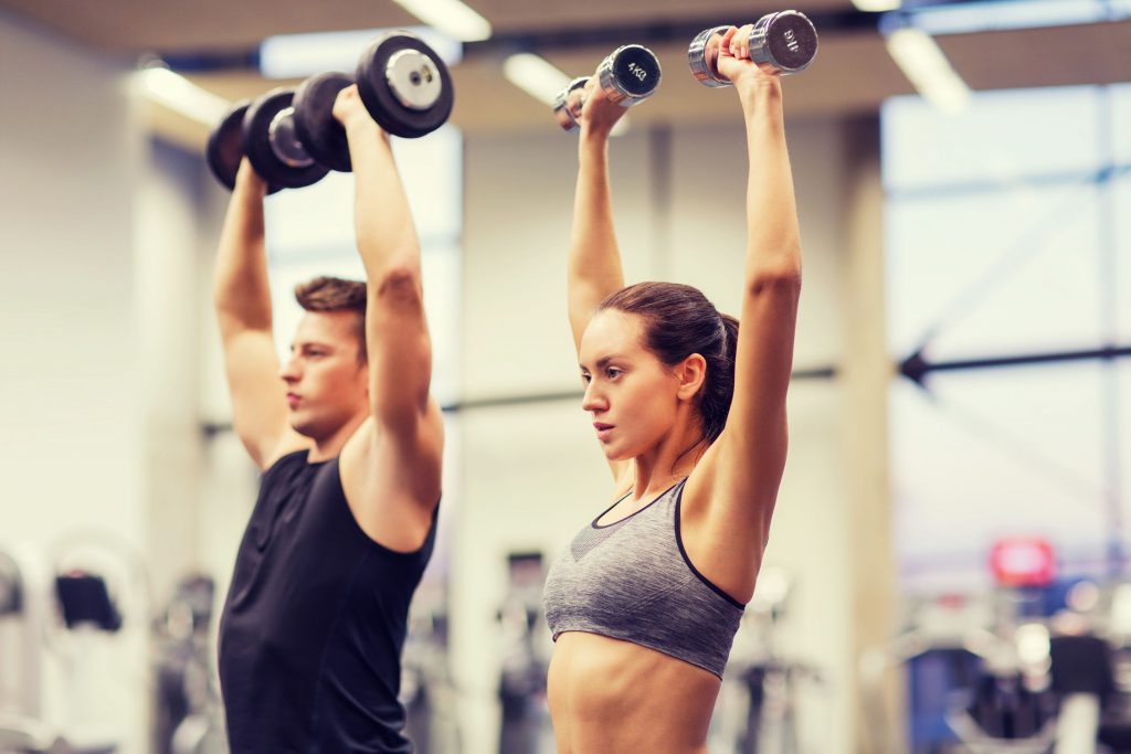 man and woman strength training with dumbbells