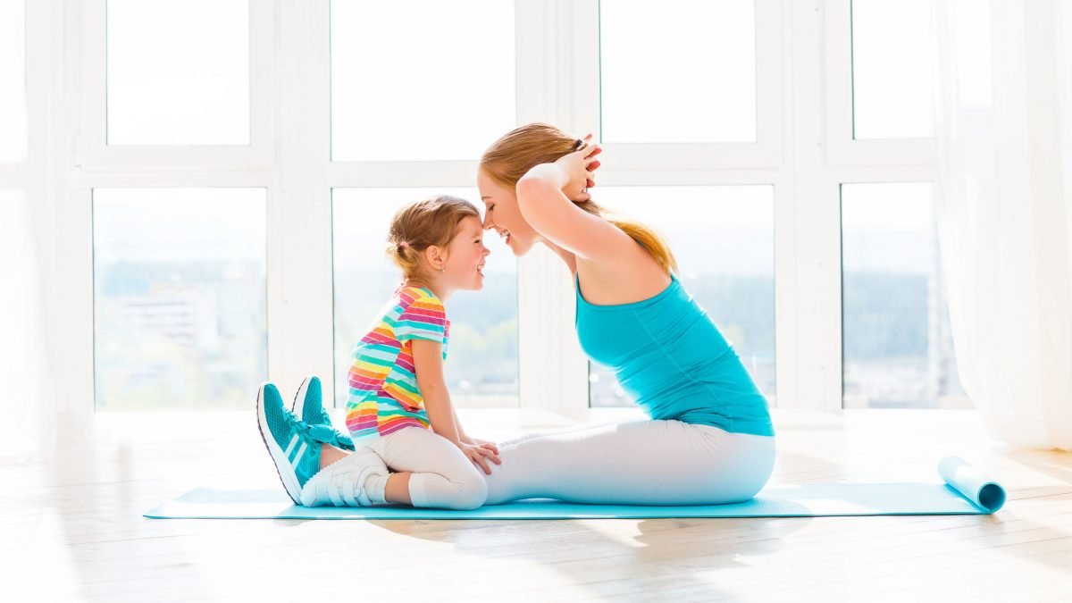 mom and daughter doing yoga together