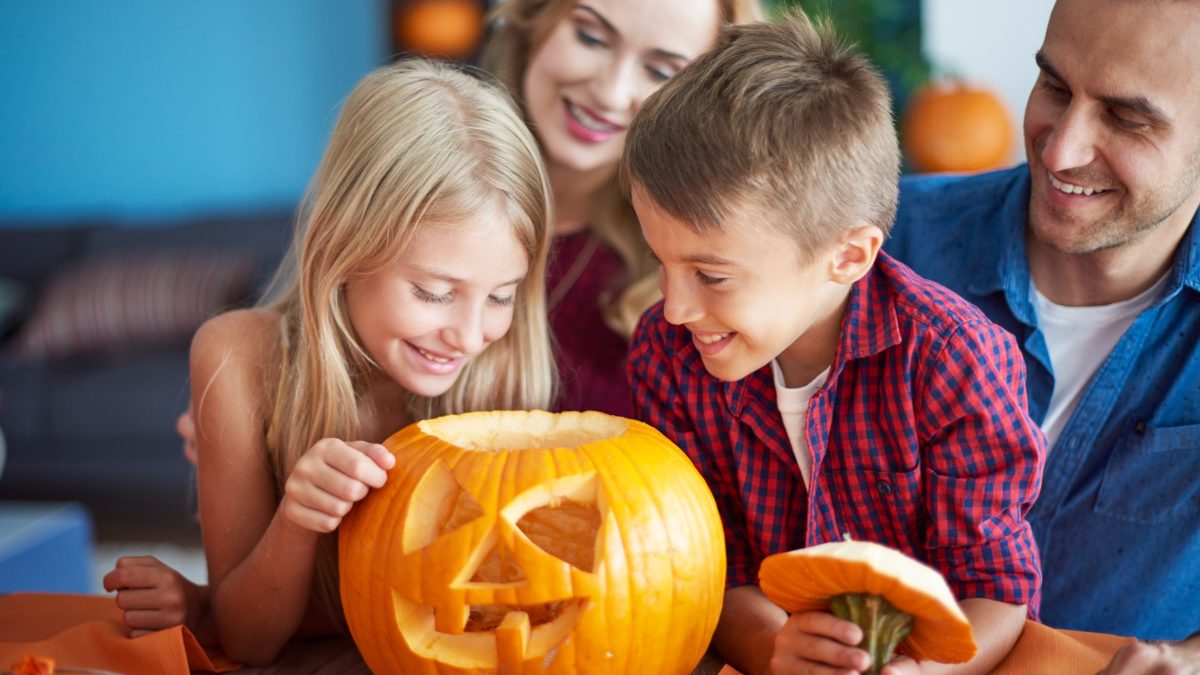 Family gathering around a pumpkin