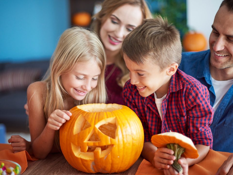 Family gathering around a pumpkin