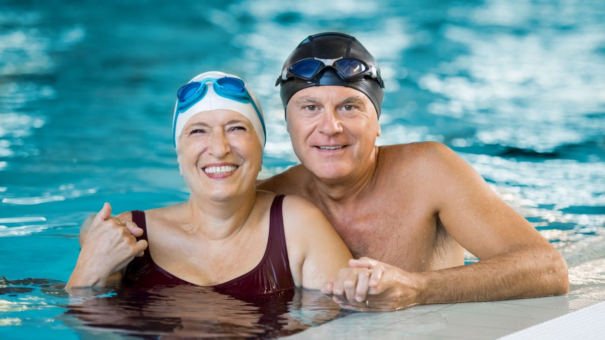 senior couple smiling while getting ready for an aquatics class