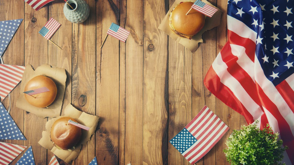 4th of July celebration with flags and burgers on a table