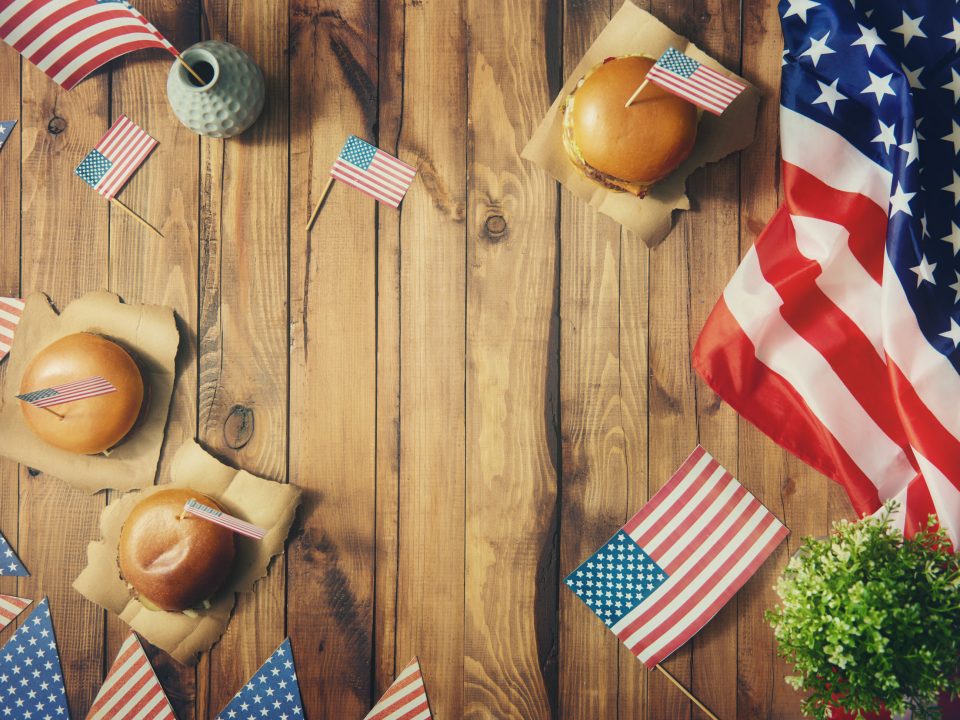 4th of July celebration with flags and burgers on a table