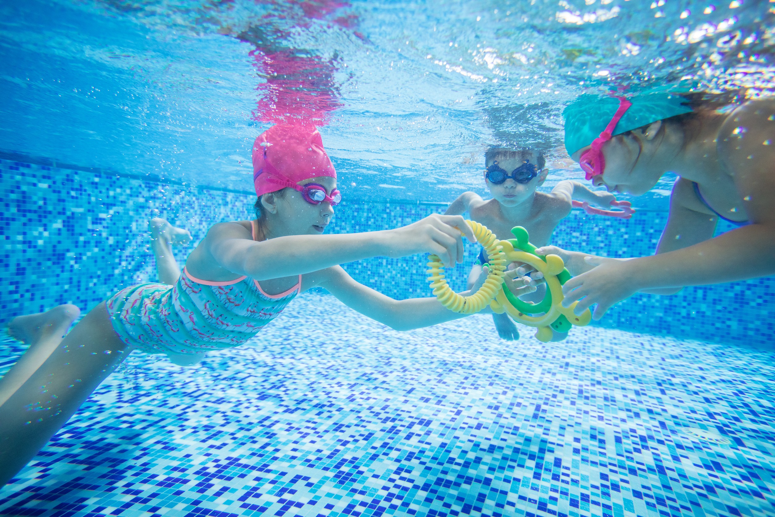 Kids playing swimming games underwater