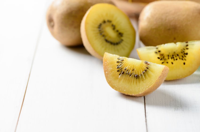 golden kiwis on a white wooden table