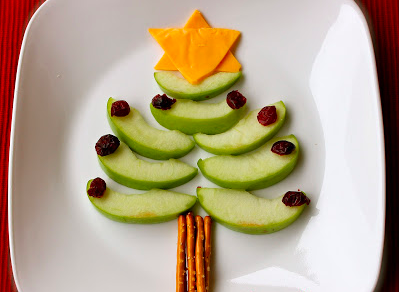 Christmas trees made from green apple slices, raisins for ornaments, pretzels for the trunk, and cheese for the star